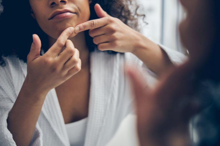 femme percer bouton points noirs comédons peau visage salle de bain