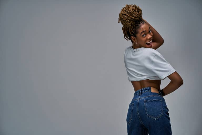 femme fesses bombées jean poches noire métisse tresses sourire mode dos