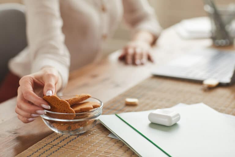 femme grignoter biscuits gâteaux grignotage manger astuce PC bureau travailler