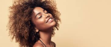 femme métisse cheveux crépus afro plaisir joie sourire bonheur fermer yeux