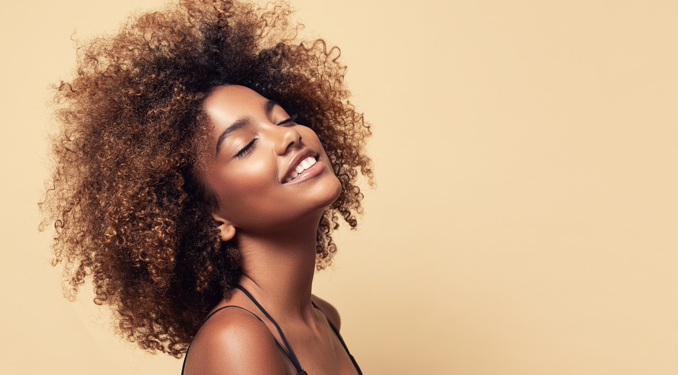 femme métisse cheveux crépus afro plaisir joie sourire bonheur fermer yeux