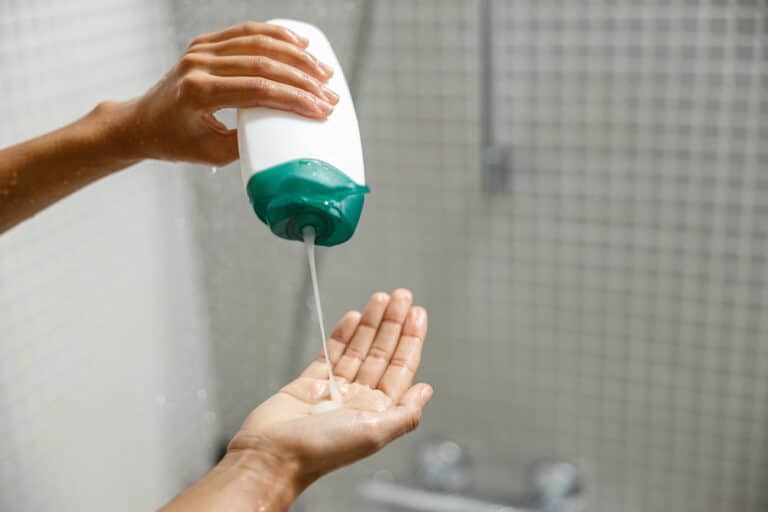 femme verser gel douche mains salle de bain hygiène corporelle produit nettoyant laver plastique