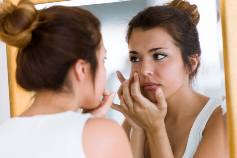 bouton acné femme miroir salle de bain remèdes naturels peau