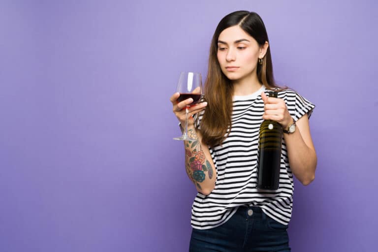 femme déguster vin rouge verre à pied bouteille boire alcool