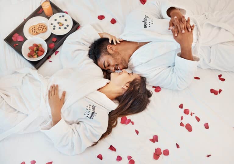 couple chambre hôtel peignoirs pétales rose fleurs lit déco romantique repas